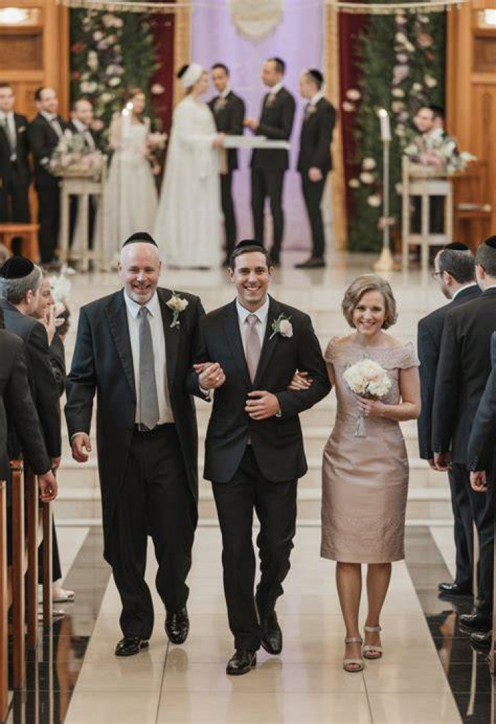 Does the groom walk down the aisle with his mom?